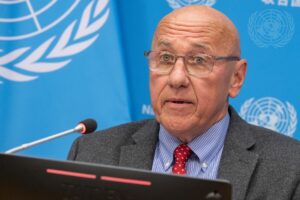 UN Special Rapporteur Tom Andrews standing at a lectern during a press briefing at the UN